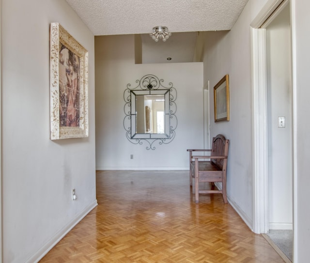 corridor with a textured ceiling and light parquet floors