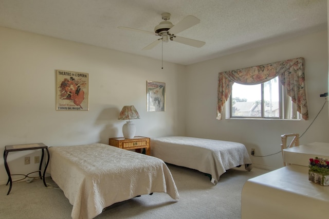 bedroom with ceiling fan, light carpet, and a textured ceiling