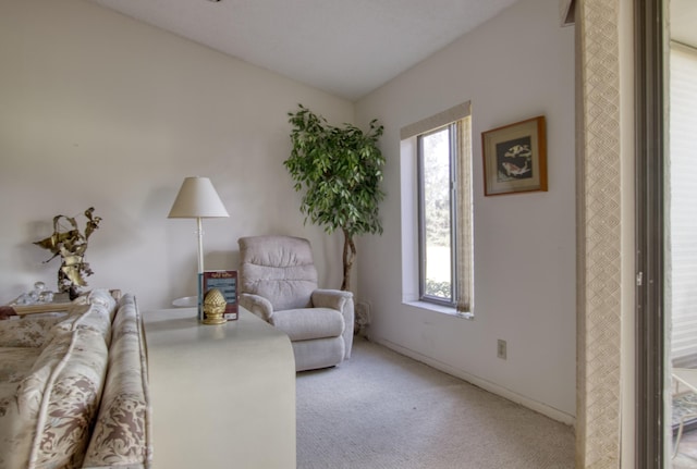 living area featuring light carpet