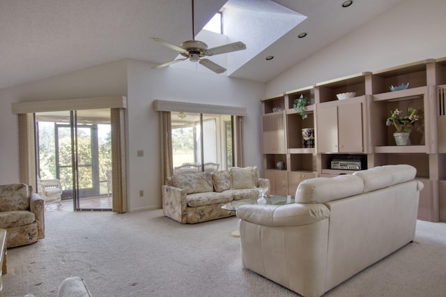 carpeted living room featuring ceiling fan, a skylight, high vaulted ceiling, and a healthy amount of sunlight