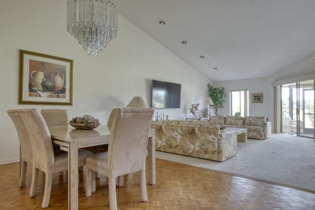 dining room with light parquet flooring and high vaulted ceiling