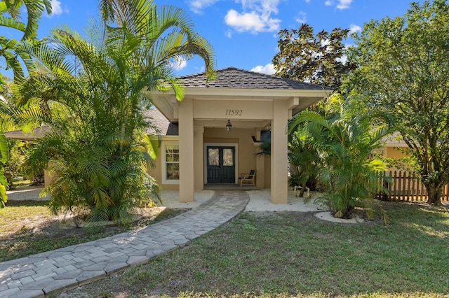 property entrance with a lawn and french doors