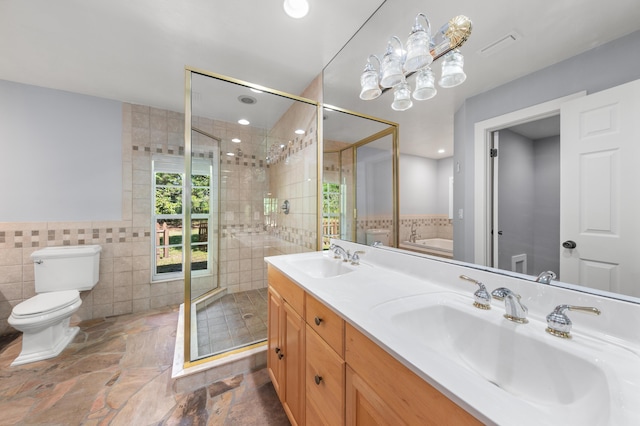 full bathroom with vanity, toilet, separate shower and tub, and tile walls