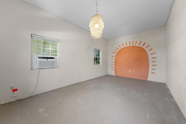 spare room featuring cooling unit, concrete floors, and a healthy amount of sunlight