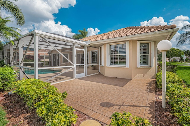 back of property featuring a lanai and a patio area