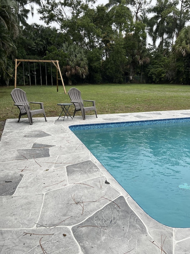 view of swimming pool with a patio area and a lawn