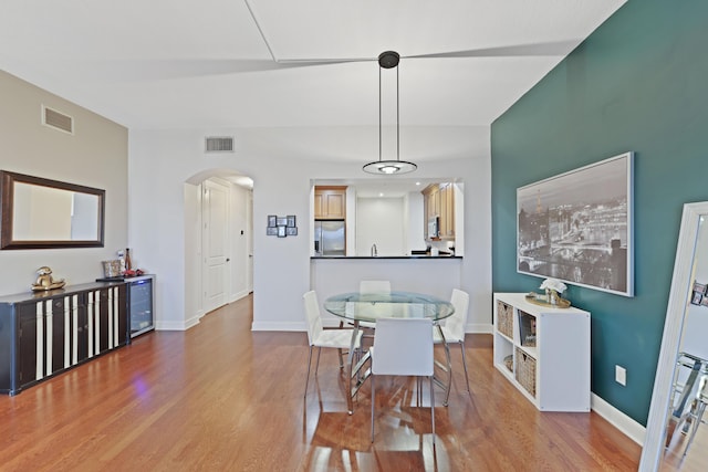 dining room with hardwood / wood-style floors and beverage cooler