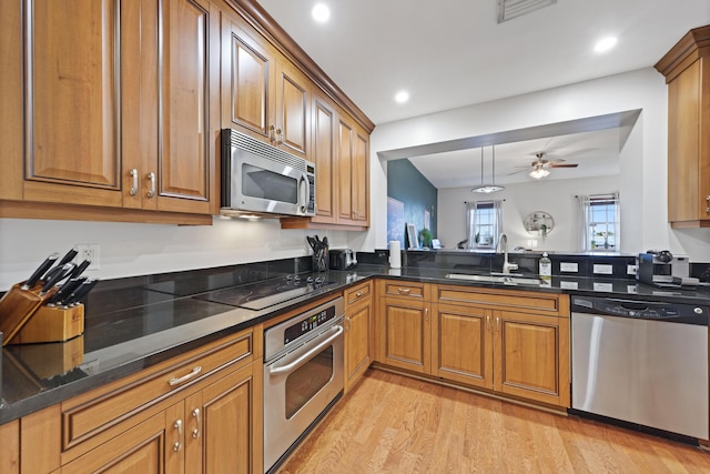 kitchen featuring pendant lighting, sink, ceiling fan, appliances with stainless steel finishes, and light wood-type flooring