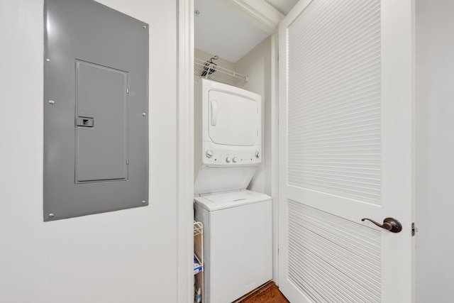 clothes washing area with stacked washer and dryer and electric panel