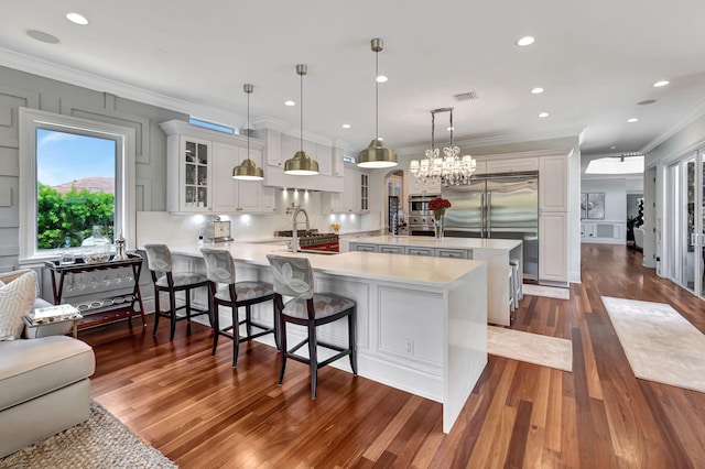 kitchen with pendant lighting, kitchen peninsula, white cabinets, and a breakfast bar