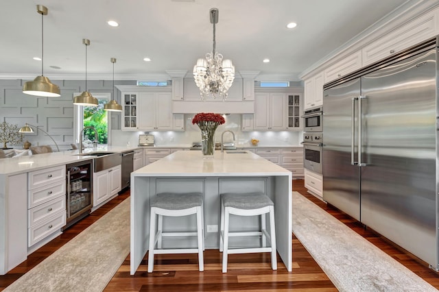 kitchen featuring wine cooler, appliances with stainless steel finishes, a center island, and white cabinets