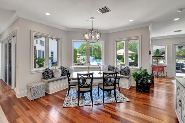 dining space with an inviting chandelier, a healthy amount of sunlight, and dark hardwood / wood-style floors