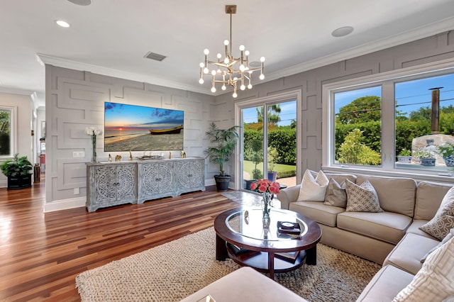 living room featuring crown molding, dark wood-type flooring, and a chandelier