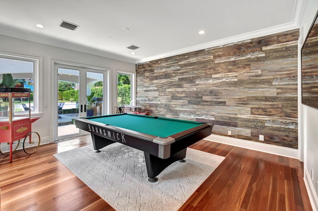 rec room featuring billiards, wooden walls, wood-type flooring, ornamental molding, and french doors