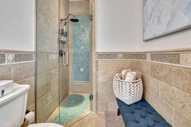 bathroom with tile walls, toilet, and walk in shower