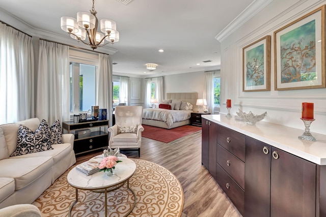 bedroom featuring crown molding, an inviting chandelier, and light wood-type flooring