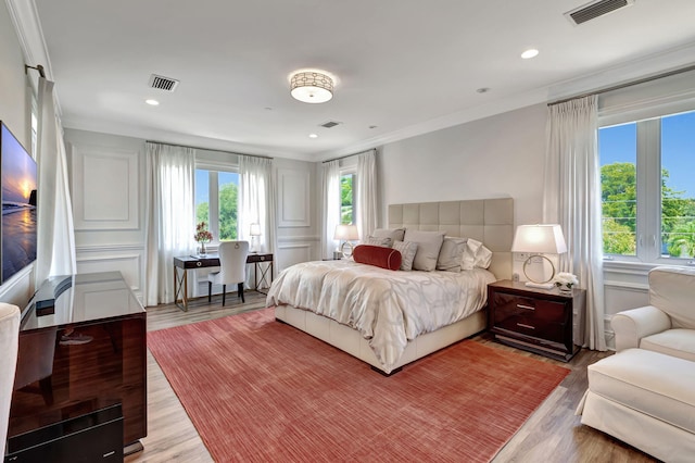 bedroom featuring crown molding and light wood-type flooring