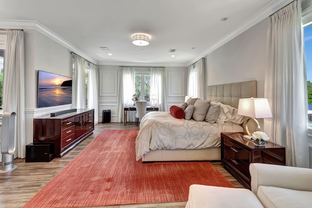 bedroom featuring ornamental molding and light hardwood / wood-style flooring