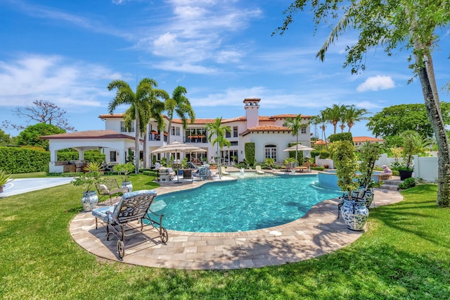 view of pool with a patio and a lawn