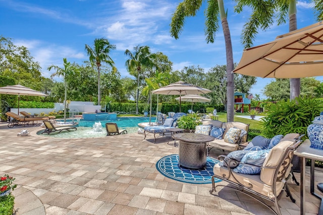 view of pool with an outdoor living space, a patio area, pool water feature, and a playground