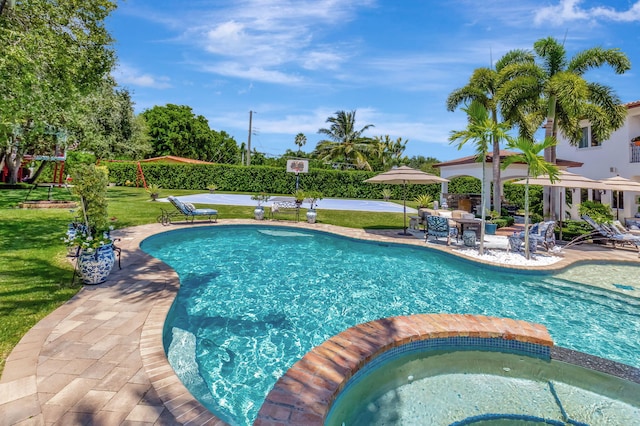 view of swimming pool featuring a patio, a yard, and an in ground hot tub