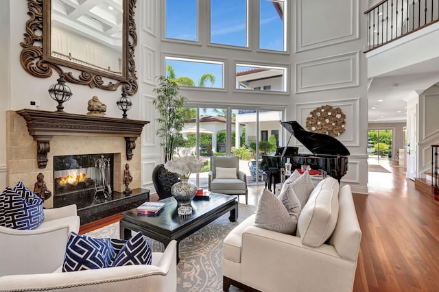 living room featuring a wealth of natural light, a high end fireplace, and wood-type flooring