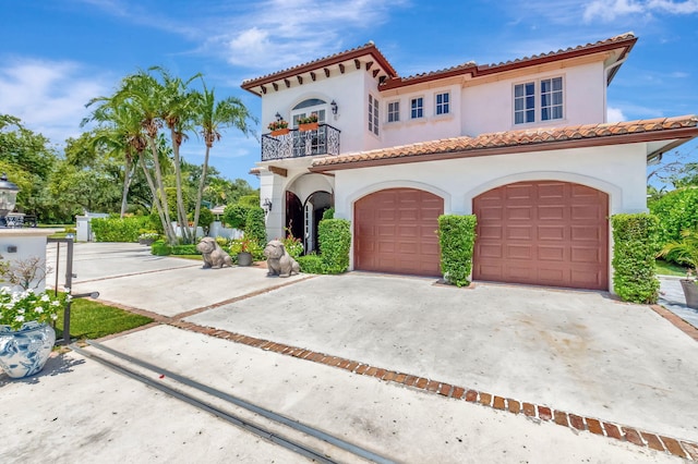 mediterranean / spanish-style home featuring a garage and a balcony