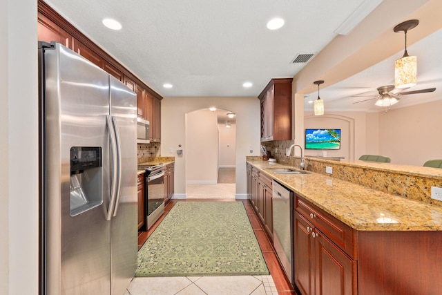 kitchen with light tile patterned flooring, sink, decorative light fixtures, appliances with stainless steel finishes, and decorative backsplash