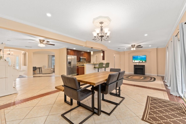 dining room featuring crown molding, ceiling fan with notable chandelier, a textured ceiling, and light tile patterned floors