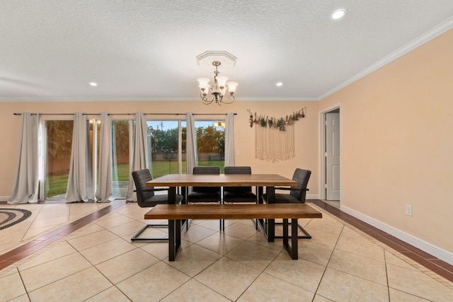 dining area with light tile patterned floors, crown molding, a textured ceiling, and a chandelier