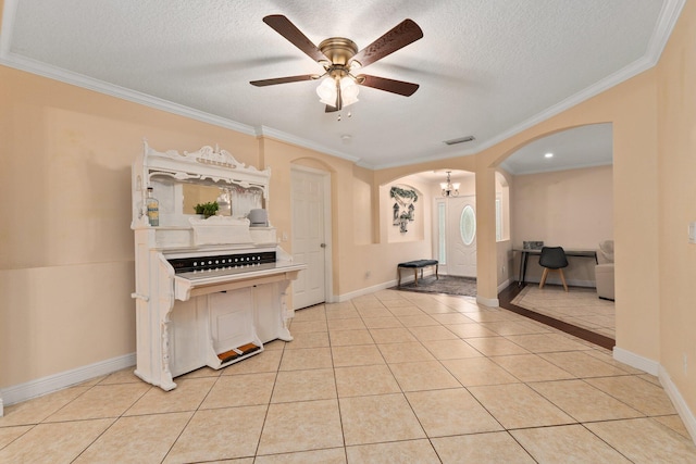 foyer entrance with light tile patterned floors, ceiling fan with notable chandelier, ornamental molding, and a textured ceiling