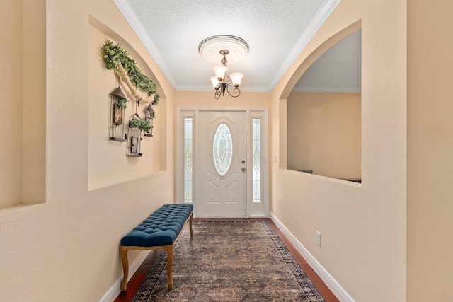 entryway featuring crown molding, dark hardwood / wood-style flooring, a chandelier, and a textured ceiling