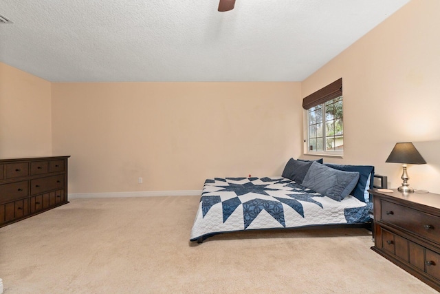 carpeted bedroom with a textured ceiling and ceiling fan