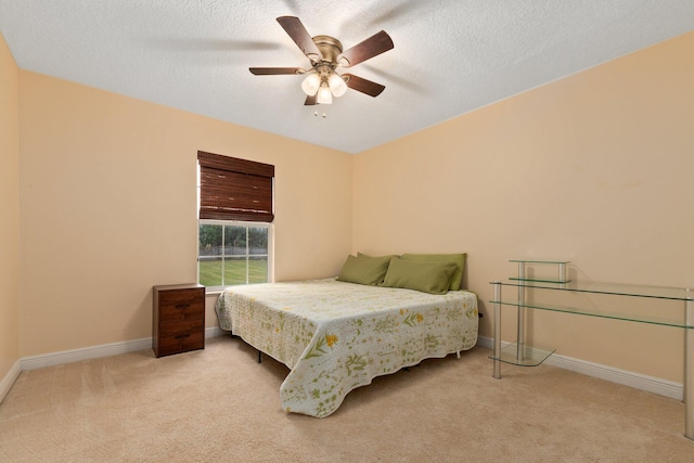 bedroom featuring light carpet, a textured ceiling, and ceiling fan