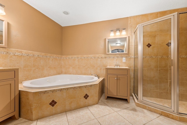 bathroom with shower with separate bathtub, tile walls, tile patterned floors, and vanity