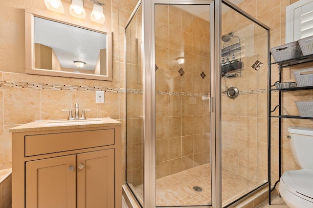 bathroom with walk in shower, vanity, toilet, and tile walls