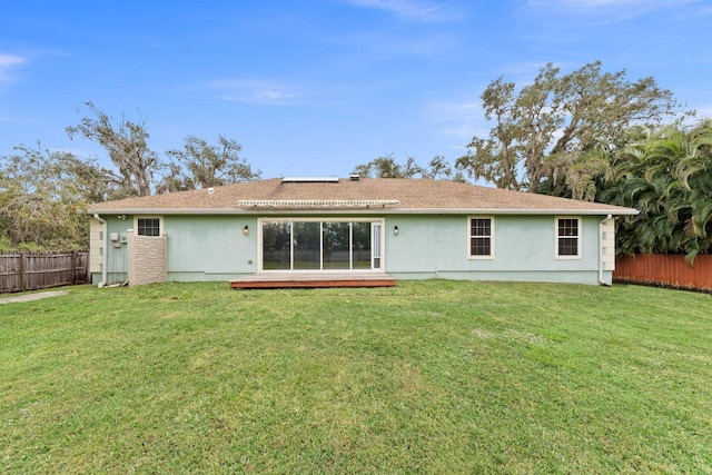 rear view of property with a lawn