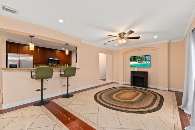 living room featuring crown molding, ceiling fan, and light tile patterned floors