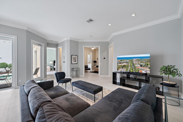 living room featuring ornamental molding, light tile patterned floors, and a textured ceiling