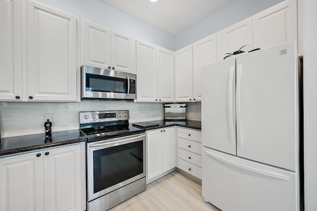 kitchen with white cabinetry, stainless steel appliances, light hardwood / wood-style floors, and backsplash