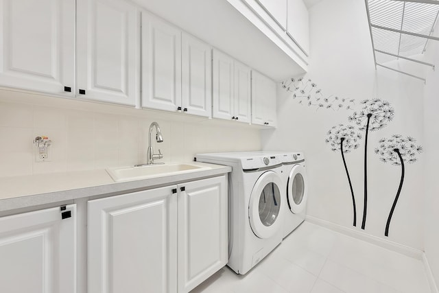 washroom featuring cabinets, sink, washer and dryer, and light tile patterned floors