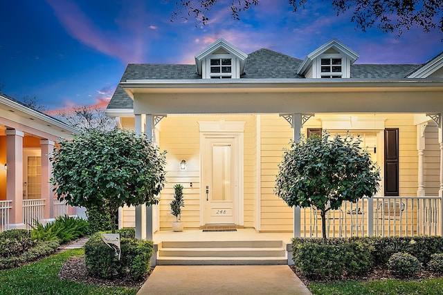 exterior entry at dusk with covered porch