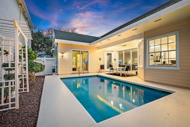 pool at dusk featuring a patio