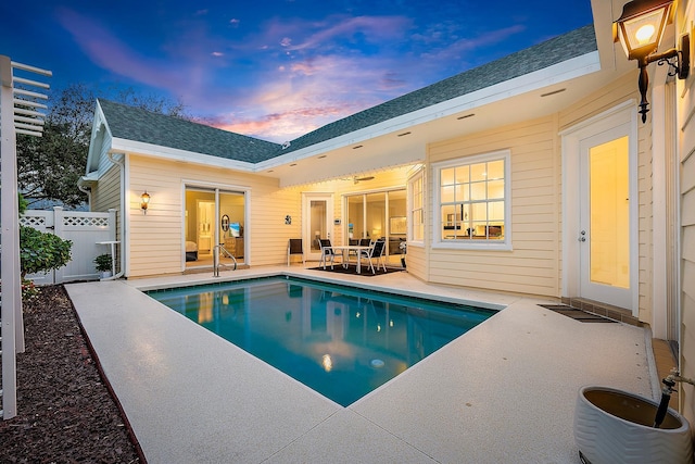 pool at dusk featuring a patio area