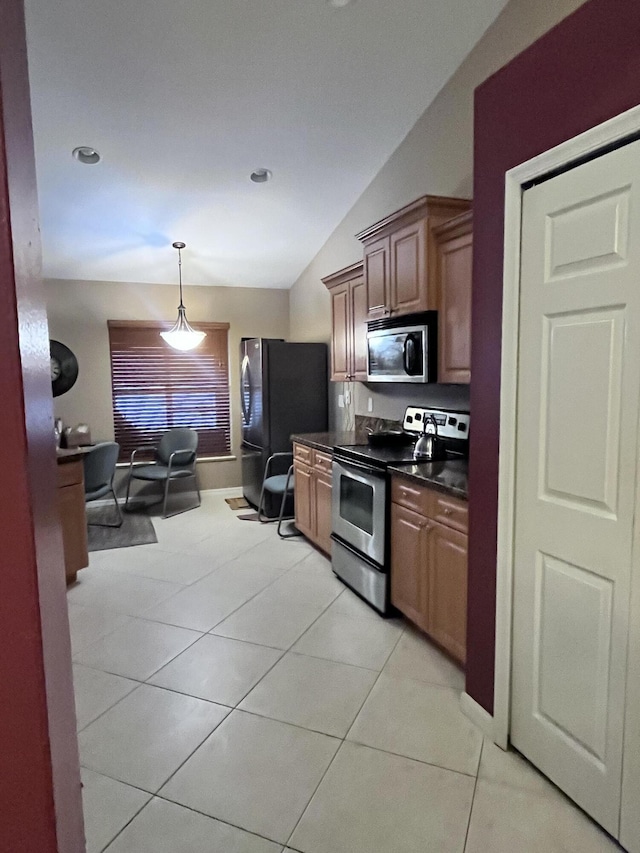 kitchen featuring pendant lighting, light tile patterned floors, lofted ceiling, and appliances with stainless steel finishes