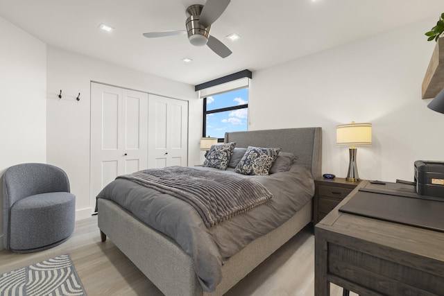 bedroom with light hardwood / wood-style flooring, a closet, and ceiling fan