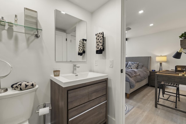 bathroom with vanity, toilet, and hardwood / wood-style floors