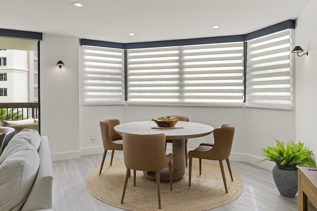 dining room with light wood-type flooring and a wealth of natural light