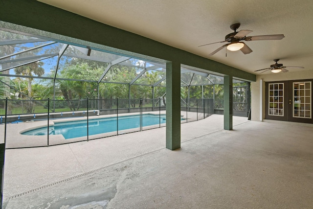 view of pool featuring ceiling fan, glass enclosure, and a patio area