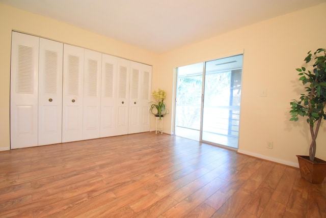 unfurnished bedroom featuring access to outside and light hardwood / wood-style floors